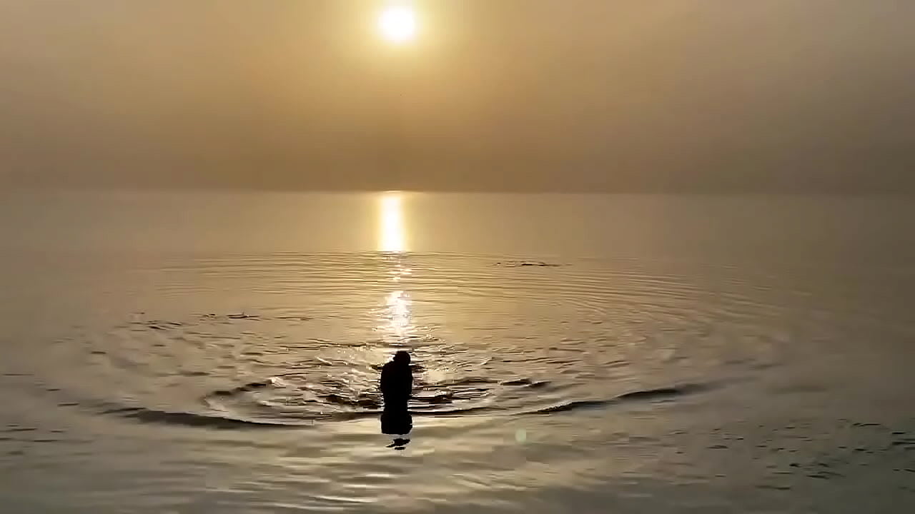 Monika Fox swims in sea at sunset
