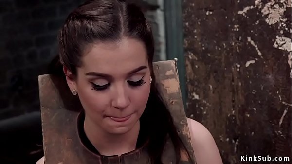 Sexy brunette teen trainee Kasey Warner has slave training in dungeon with two master which put her in wooden shackles and fuck her pussy and mouth  