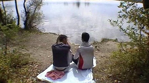 Two buddies go down on each other on a river bank