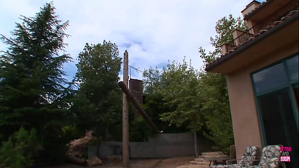 A woman with red hair wearing seductive undergarments receives a facial ejaculation while standing next to her husband, who enjoys seeing her engage in sexual activities with other men  