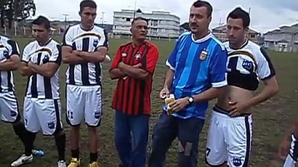 Rodinha de jogadores pegando no pau durante treino.