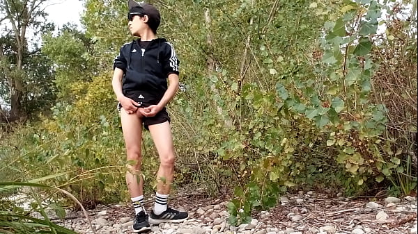 Cute gay boy takes off his boxer, walk without underwear, masturbates his penis throught his short shorts, and ejaculates sperm outside in nature 