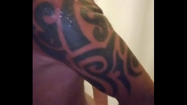 A public shower at the gym surrounded by studs 