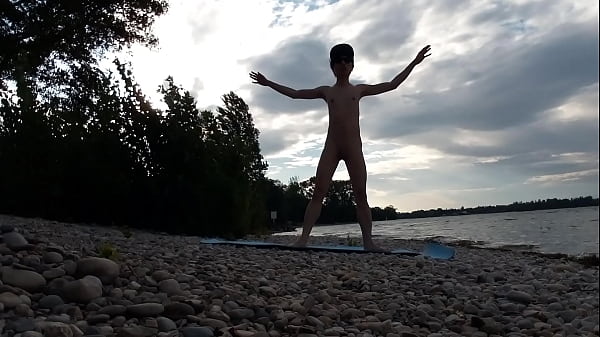 Skinny naturist twink practices naked yoga on a nudist beach 