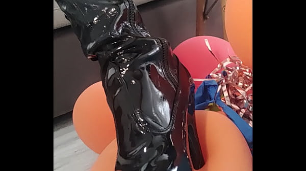 Veve předv&aacute;d&iacute; prask&aacute;n&iacute; bal&oacute;nků v latexov&yacute;ch kozačk&aacute;ch s ostr&yacute;m podpatkem