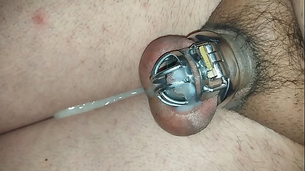 Maricon viniendose en jaula de castidad