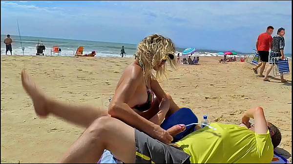 Milf makes stranger ejaculate with skillful handjob right on the beach