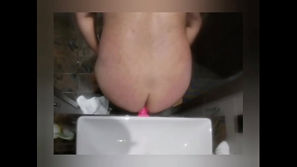 Toying ass with pink dildo in bathroom 