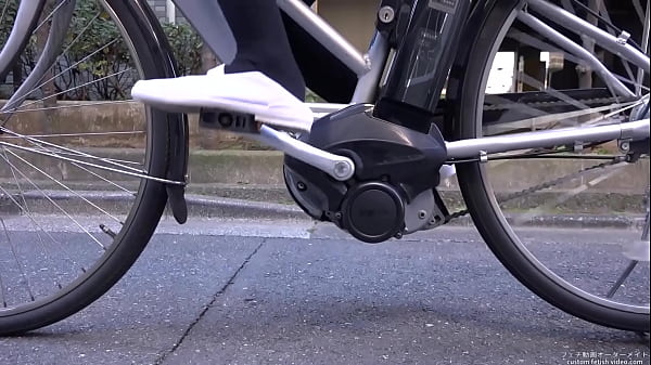 Woman riding a bicycle stepping on the heel of shoes