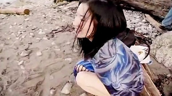 Asian slut is on the beach naked posing
