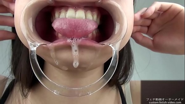 A woman shows her gums and sputs saliva