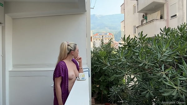 Flashing her tits on a public balcony.  