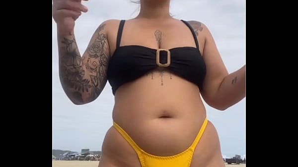 USANDO UM BIQUINI AMARELO BEM APERTADO RACHANDO A BUCETA PRA CHAMAR ATEN&Ccedil;&Atilde;O NA PRAIA