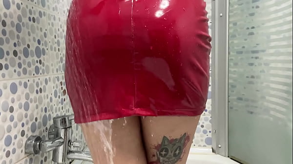 Streams of water sexually cover Mistress's body and her rubber dress. Rubber fetish.  