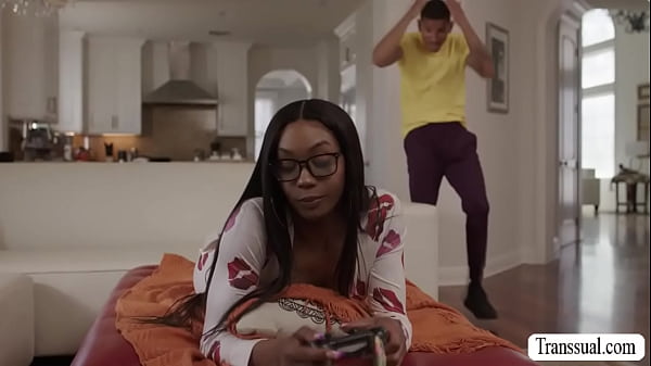 Ebony Leilani is playing video games when Axel attempts to distract her with his dick, wanting to get some action
