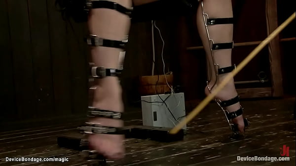 Chained in eagle spread position blonde lesbian slave Ash Hollywood with head in open front box gets hard whipped then mummifed fucked with dildo on a stick by lezdom Claire Adams