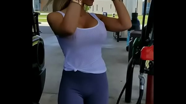 Beautiful babe pumping gas  