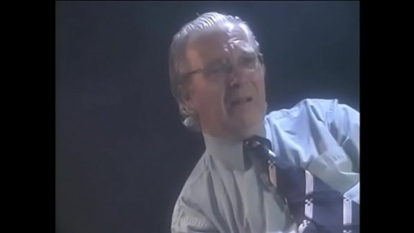 Two lesbians bring each other to orgasm with the help of toys while a man in a chair watches them  