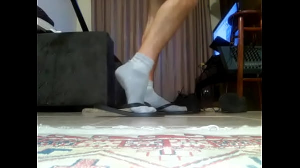 Rapaz brincando de chinelo com meia 