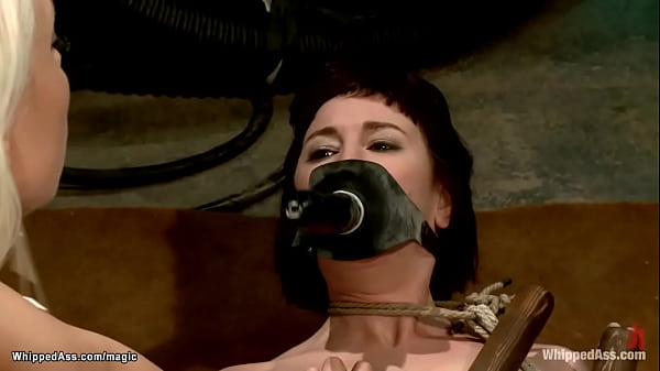 Brunette lesbian slave Coral Aorta in black lingerie is bound to wooden sticks and hard whipped by blonde lezdom Lorelei Lee then pussy fisted