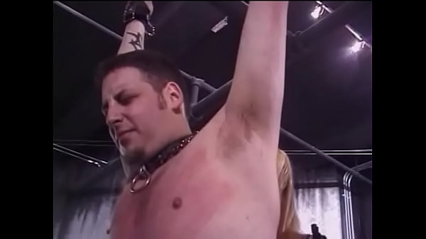 Two horny chicks in latex suits spank tied dude with whips