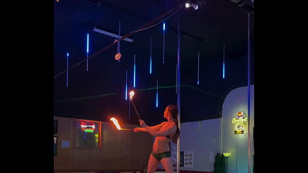 Destiny Mae dancing and playing with fire on stage at the strip club 