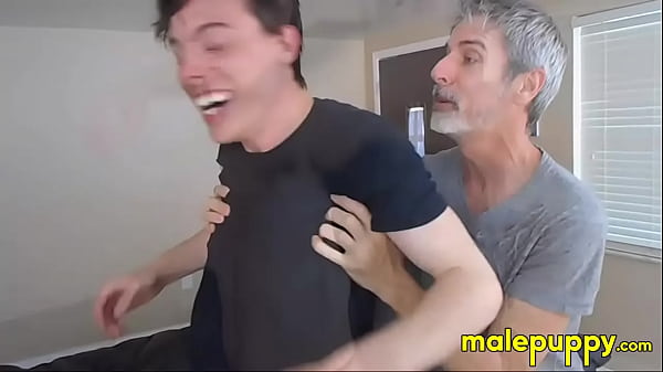 Richard Lennox straddles Aiden to pin him down and pulls off his shoes, tickling his feet through his dirty socks 