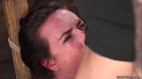 Brunette slave Casey Calvert in squat position with wrists and neck tied to wooden post gets deep throat fucked then rough pussy banged by big cock baldheaded master Derrick Pierce  