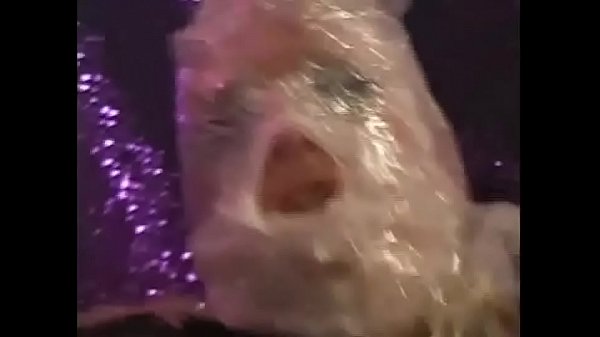 Slave wrapped in latex and cellophane gives a deep blowjob