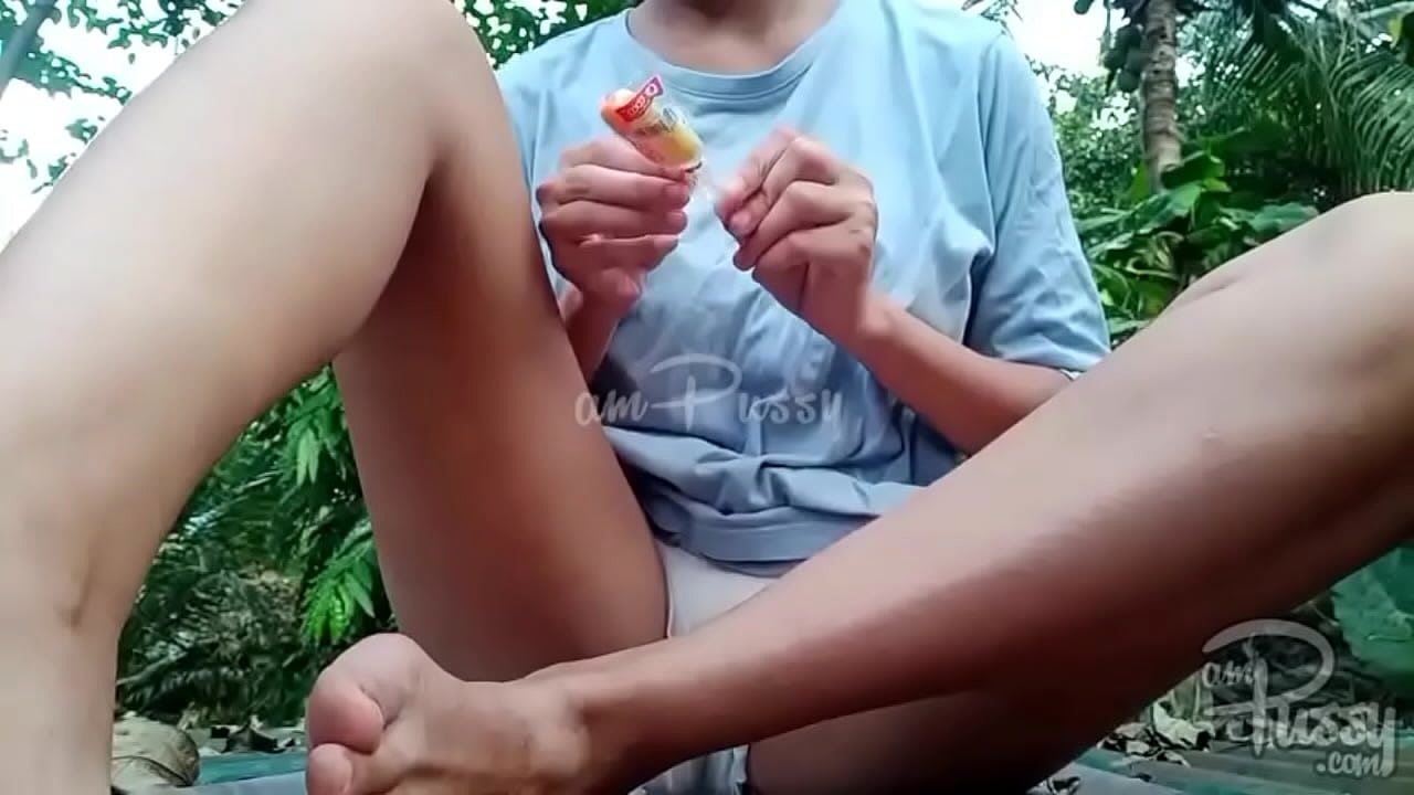 Asian girl stuffing her pussy with lollipop outdoors