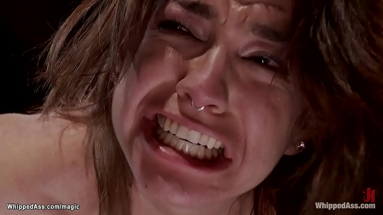 Bound brunette lesbian slave Bianca Stone is straddled on wooden pony then whipped and anal fucked with dick on a stick in hands of MILF Aiden Starr