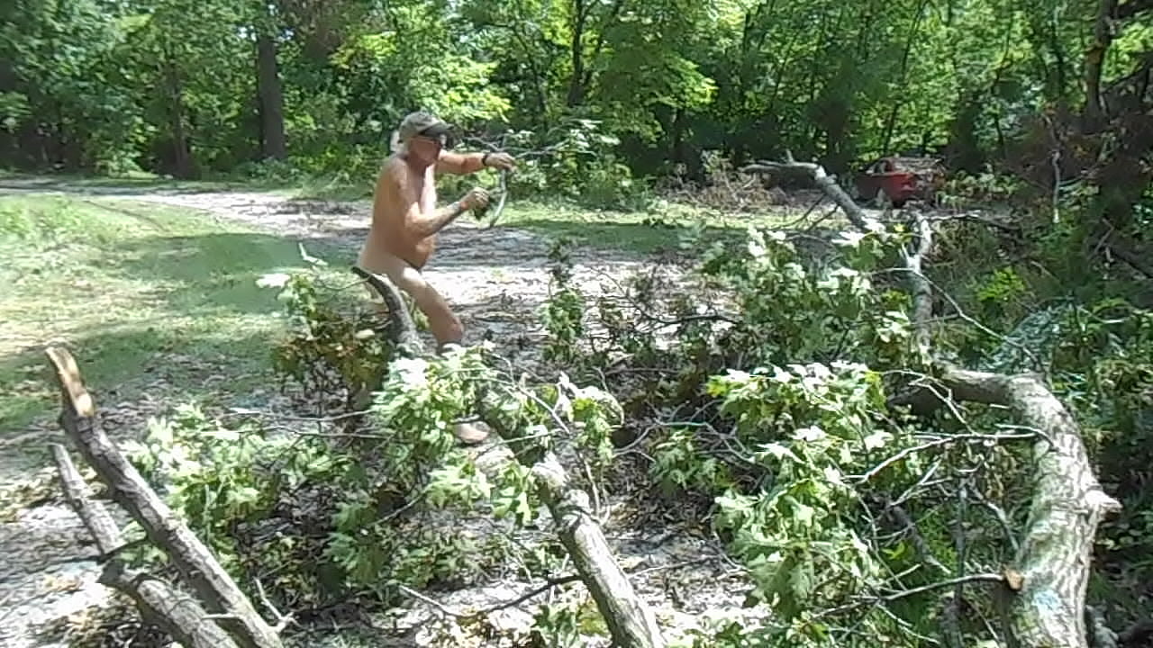 Naked Driver removes fallen limbs from a gravel road naked