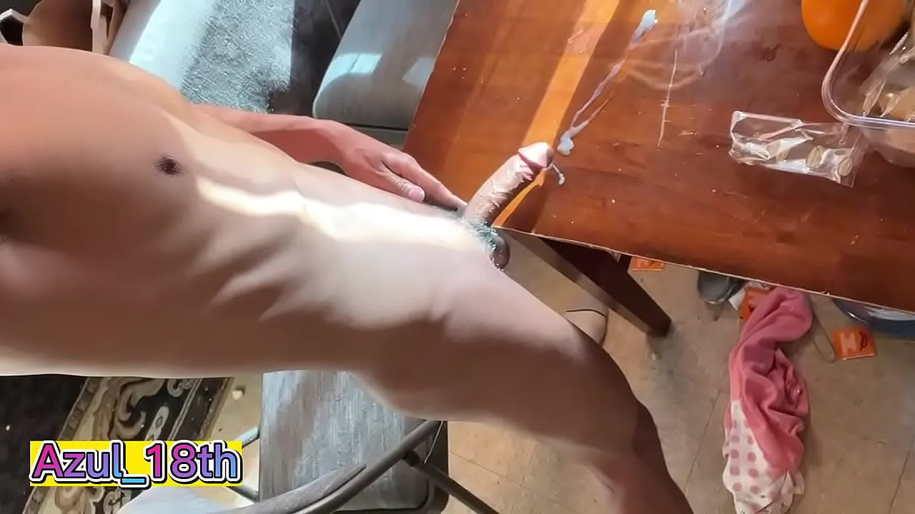 Un joven se masturba y eyacula sobre la mesa