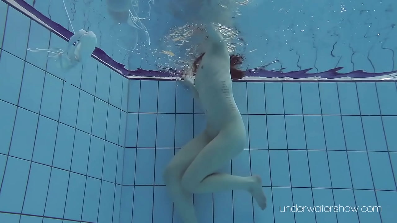 Floating babe in the warm pool getting naked