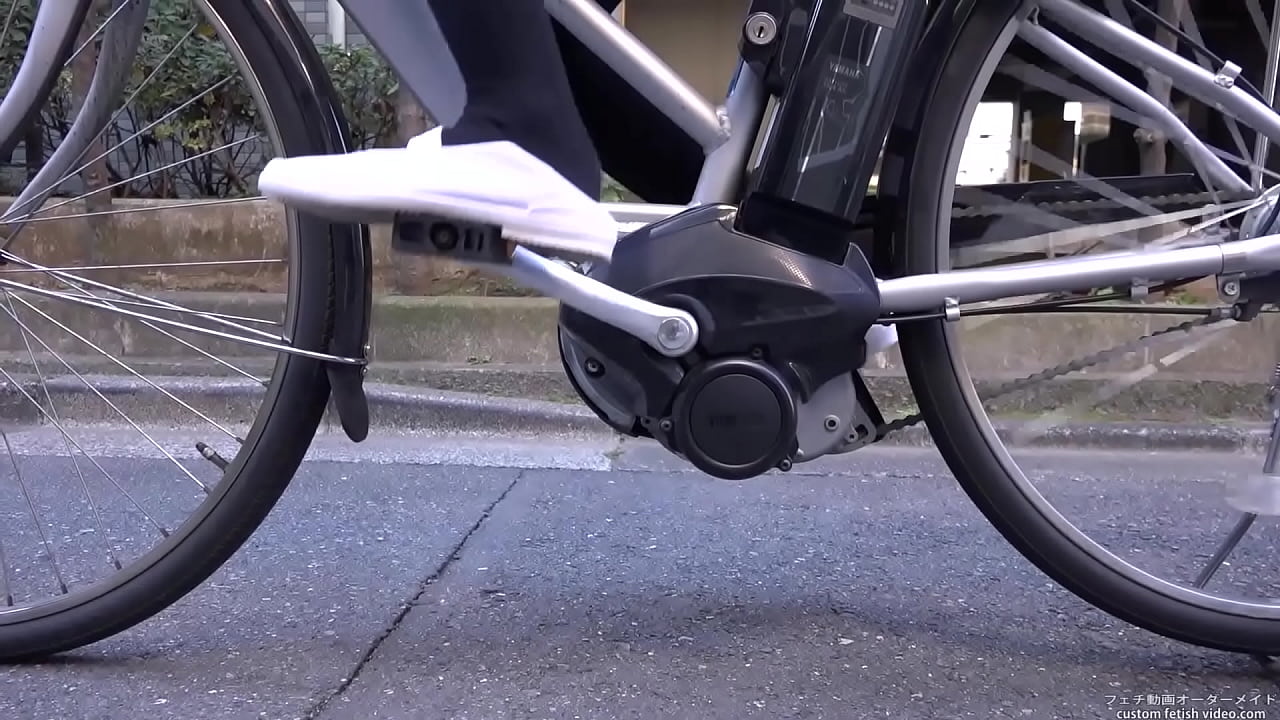Woman riding a bicycle stepping on the heel of shoes