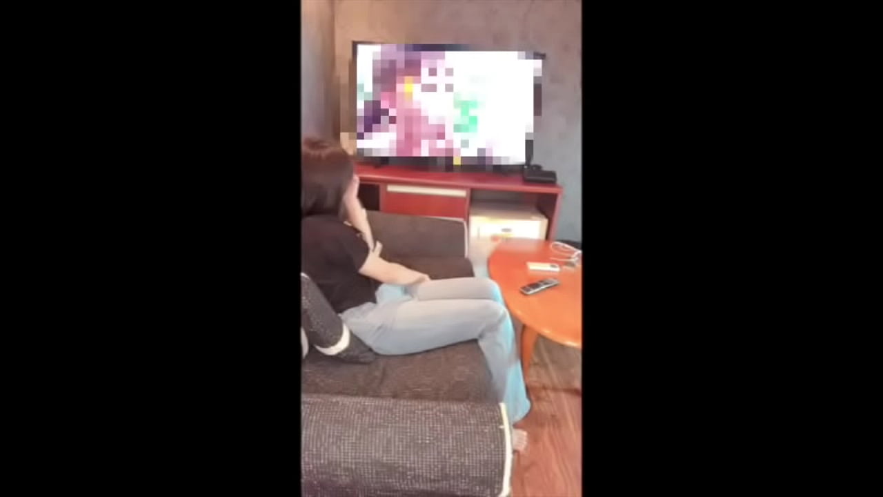 Cute woman masturbating while watching a pornographic video