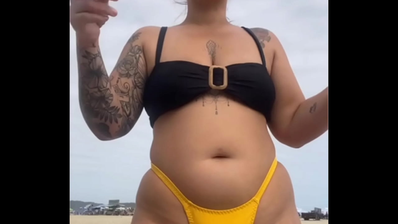 USANDO UM BIQUINI AMARELO BEM APERTADO RACHANDO A BUCETA PRA CHAMAR ATEN&Ccedil;&Atilde;O NA PRAIA