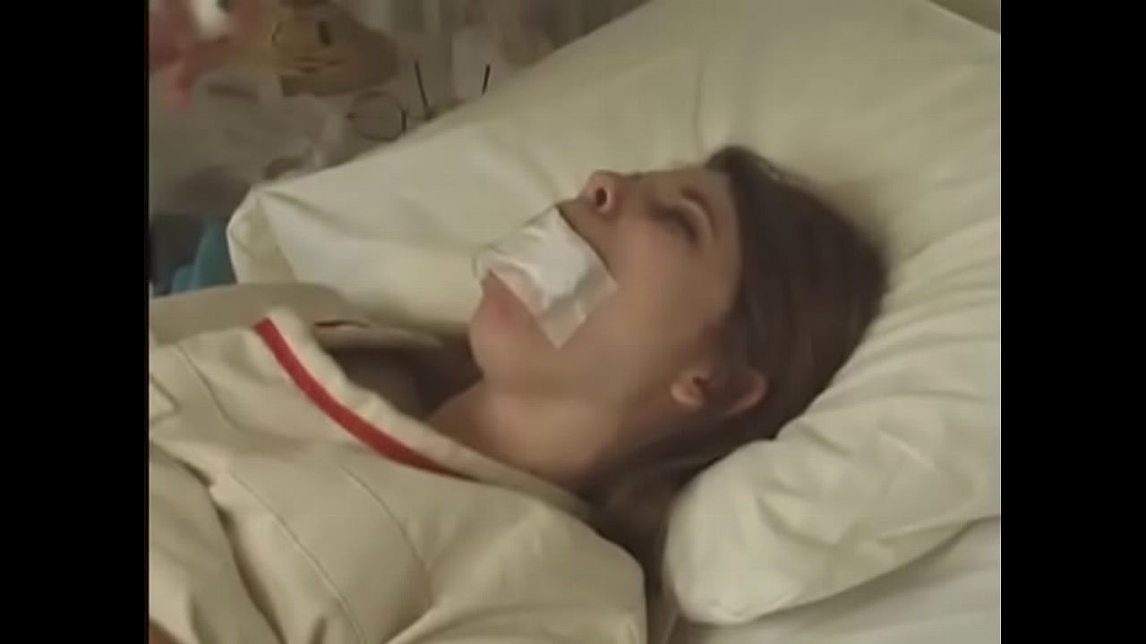 Pretty brunette in Straitjacket taped mouth tied to bed hospital