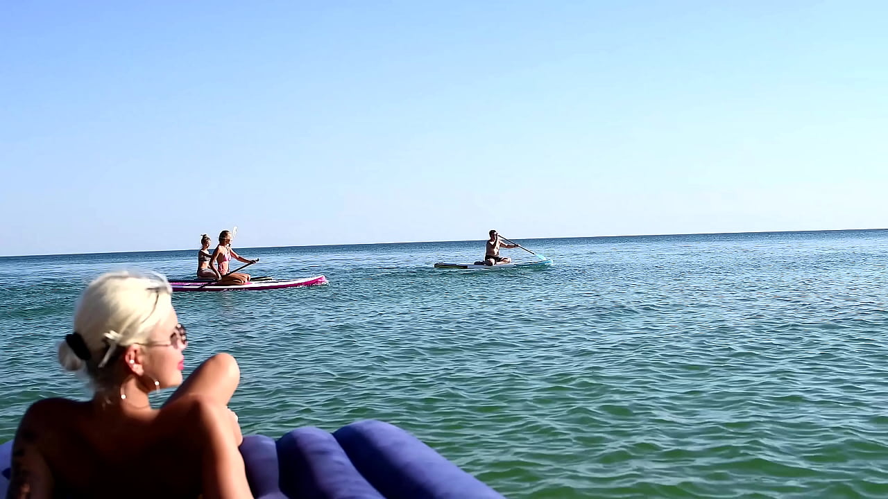 I spy on the beach as a girl with big boobs sunbathes in front of the public and dolphins