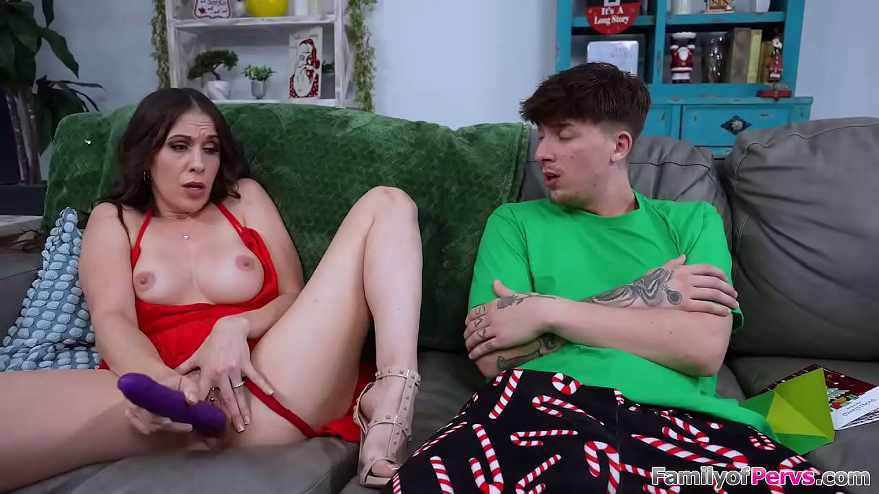 Stepson got his busty stepmom Amiee Cambridge a dildo for Xmas.The big tits brunette milf invites him to watch her toy while he strokes his big cock