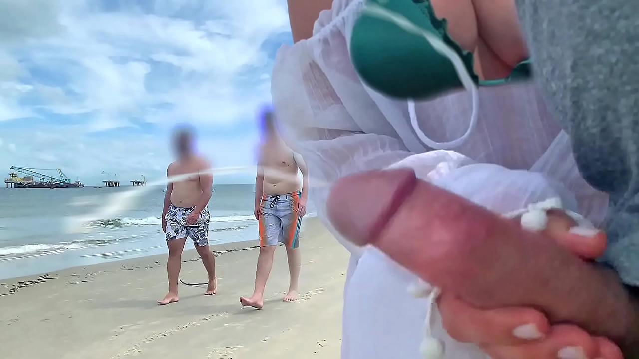 Busty milf takes stranger's cock out of pants right on the beach