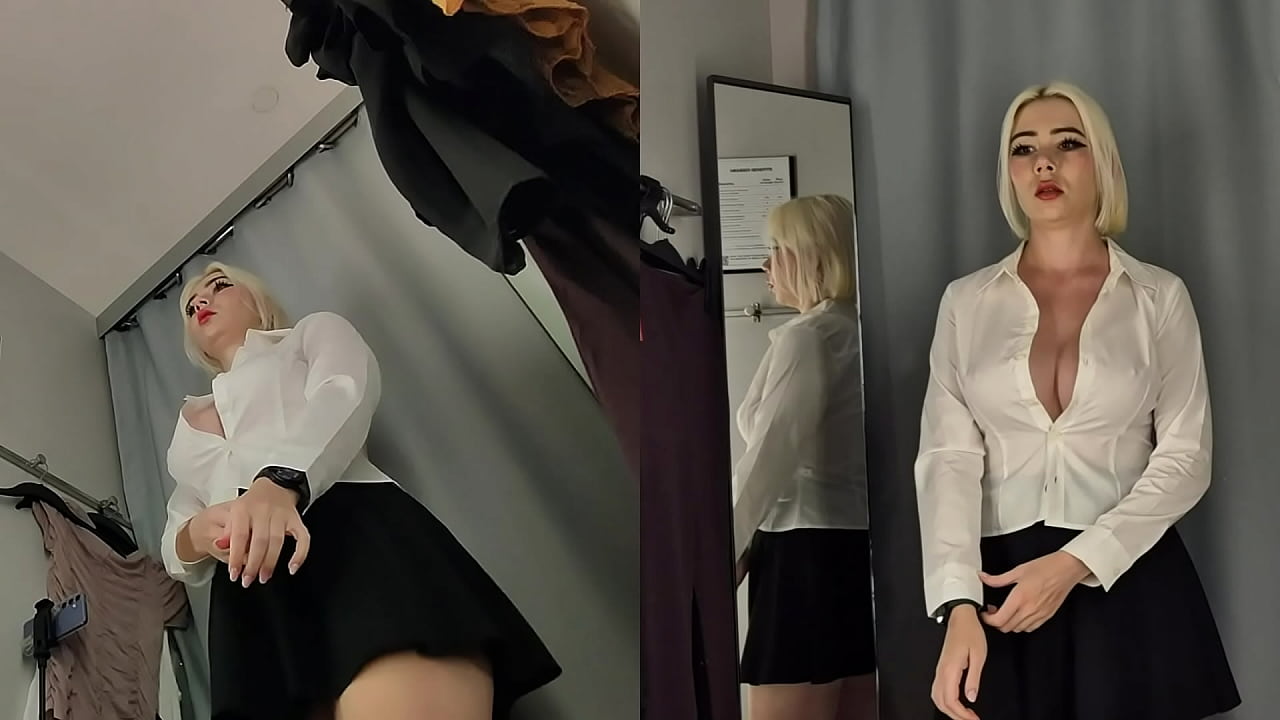 Camera in the fitting room. Trying on clothes by a beautiful blonde