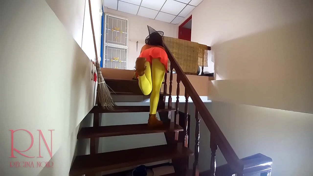 HALLOWEEN Witch in Rtgina Noir witch with pumpkins and a broom. Regina Noir Velma Dinkley Yellow pantyhose Performing in old house at stairway