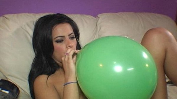 Ava Jay blows to pop balloons  