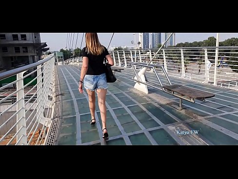 Katya is waering a sexy shorts and a pair of stiletto high heels . when she walks her high heels are clicking on the glass floor of the bridge