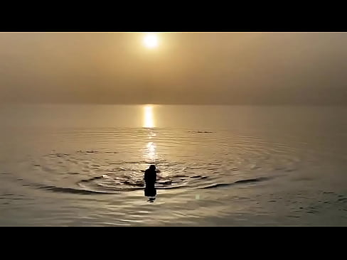 Monika Fox swims in sea at sunset