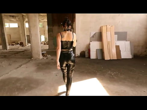 Brunette walking around in leather leggings, high heels and sword belt