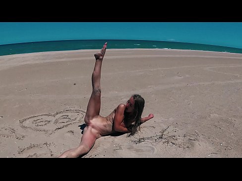 Naked excited nudist with perfect ass and small tits having fun and dancing on the beach in Valencia